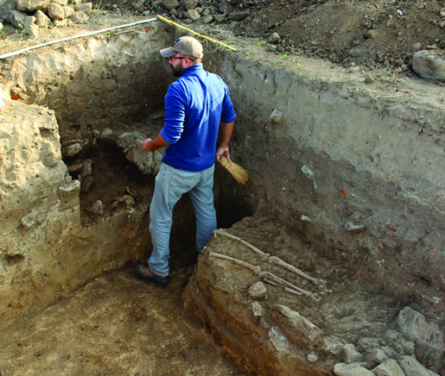 Fig. 6. Mormânt cu oase umane în zidul roman refolosit (Campania 2023) – curățarea mormântului de către drd. Ștefan Popa.